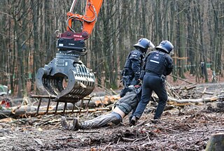 Ein Umweltdemonstrant wird von der Polizei aus dem Dannenröder Wald in Deutschland entfernt
