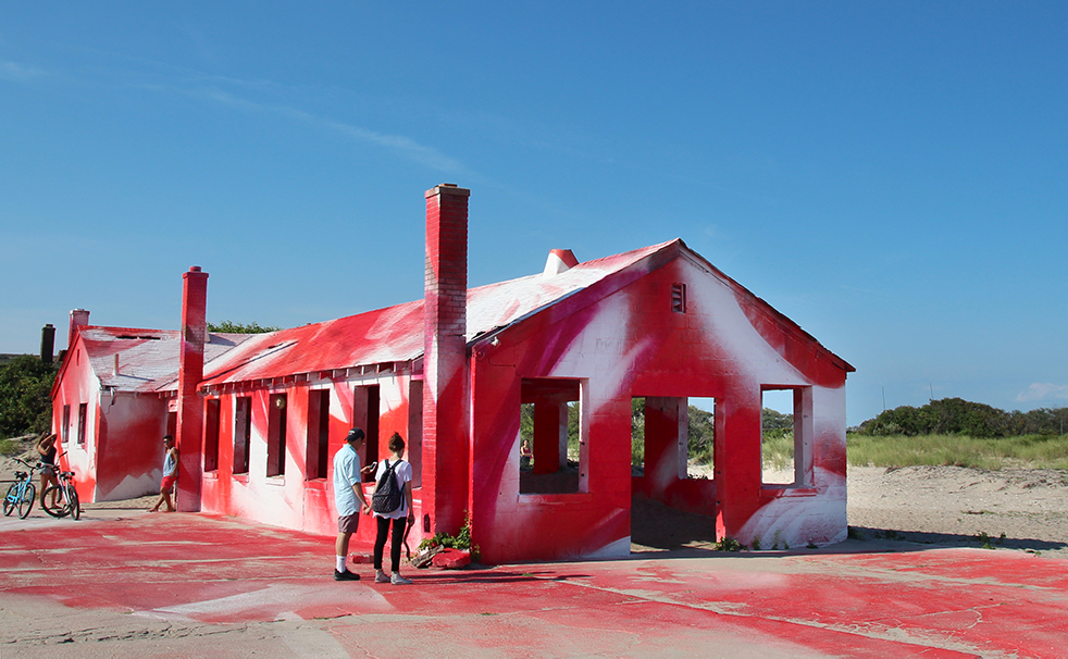 Installation von Katharina Grosse an einer vom Wirbelsturm „Sandy“ zerstörten Militärbaracke am Strand von New York, USA: Das Bild des pink und rot angesprühten Hauses entwickelte sich zum viralen Hit auf Instagram, wo es in wenigen Monaten tausendfach hochgeladen wurde. 