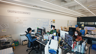 Im Büro von Superbin arbeiten mehrere Menschen an ihren Schreibtischen 