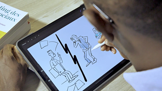Dessinateur de BD faisant des croquis de personnages sur une tablette.