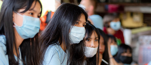 Nahaufnahme von Schülerinnen mit Maske.