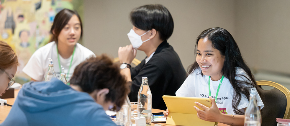 Five people at a table talking