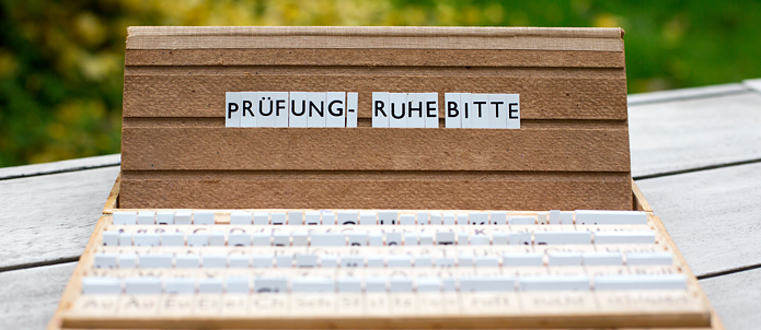 Uma caixa com as palavras em alemão: "Pr´üfung, ruhe bitte".