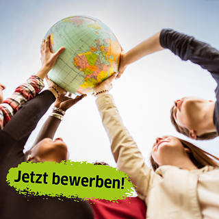 Mehrere Jugendliche halten gemeinsam einen Globus in die Höhe. Aufnahme von unten gegen den Himmel.