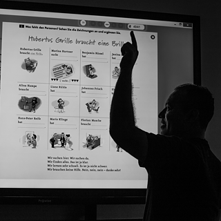 Um professor ensina no quadro interativo