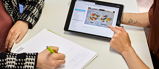 Image of two people learning a language with an iPad