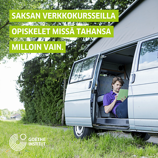 Ein Mann liest von einem Tablet in einem Camping van