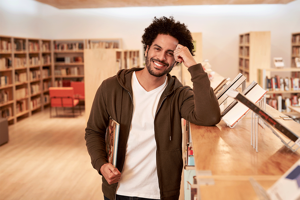 jovem em biblioteca olha para a câmera e sori