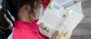 A teenager looks at the book “Kawin in Germany”.