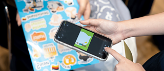 A person taps their smartphone to play an animation.