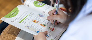 One person ticks solutions in the book "Kawin in Germany".