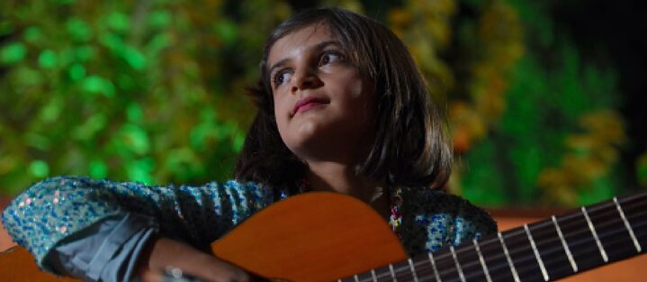 Schülerin spielt im Oktoberkonzert Gitarre in Halabja
