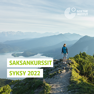 Eine Frau steht auf einen Berg und schaut die Landschaft an