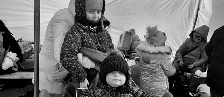 Schwarzweißfoto eines Kleinkindes und eines kleinen Mädchens in Winterjacken