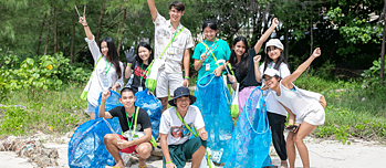 Eine Gruppe von Schüler*innen beim Müllsammeln am Strand