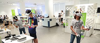 In der Bibliothek stehen Menschen mit VR-Brillen