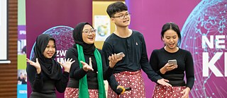 Vier Personen tragen traditionelle Kleidung und singen.