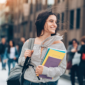 Eine lächelnde Studentin hält Büchern