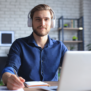 Confident man with headphones sitting in front of laptop