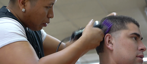 Closeup of barbar shaving client's head; 