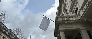 White flag hanging outside the Goethe-Institut London on a grey, rainy day