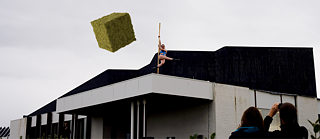 FRZNTE against on Nordic House roof against blue sky. Moss cube floating in mid-air.