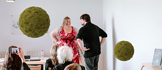 Two people facing each other dancing in front of the audience