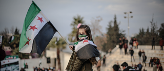 Portrait of a girl holding a Syrian flag. 