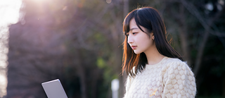 eine Frau vor einem Laptop sitzend