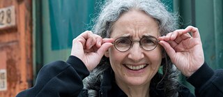 Foto der Komponistin Carola Bauckholt, auf dem sie sich an die Brille fasst