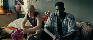 Toubab - Two men are sitting on a sofa