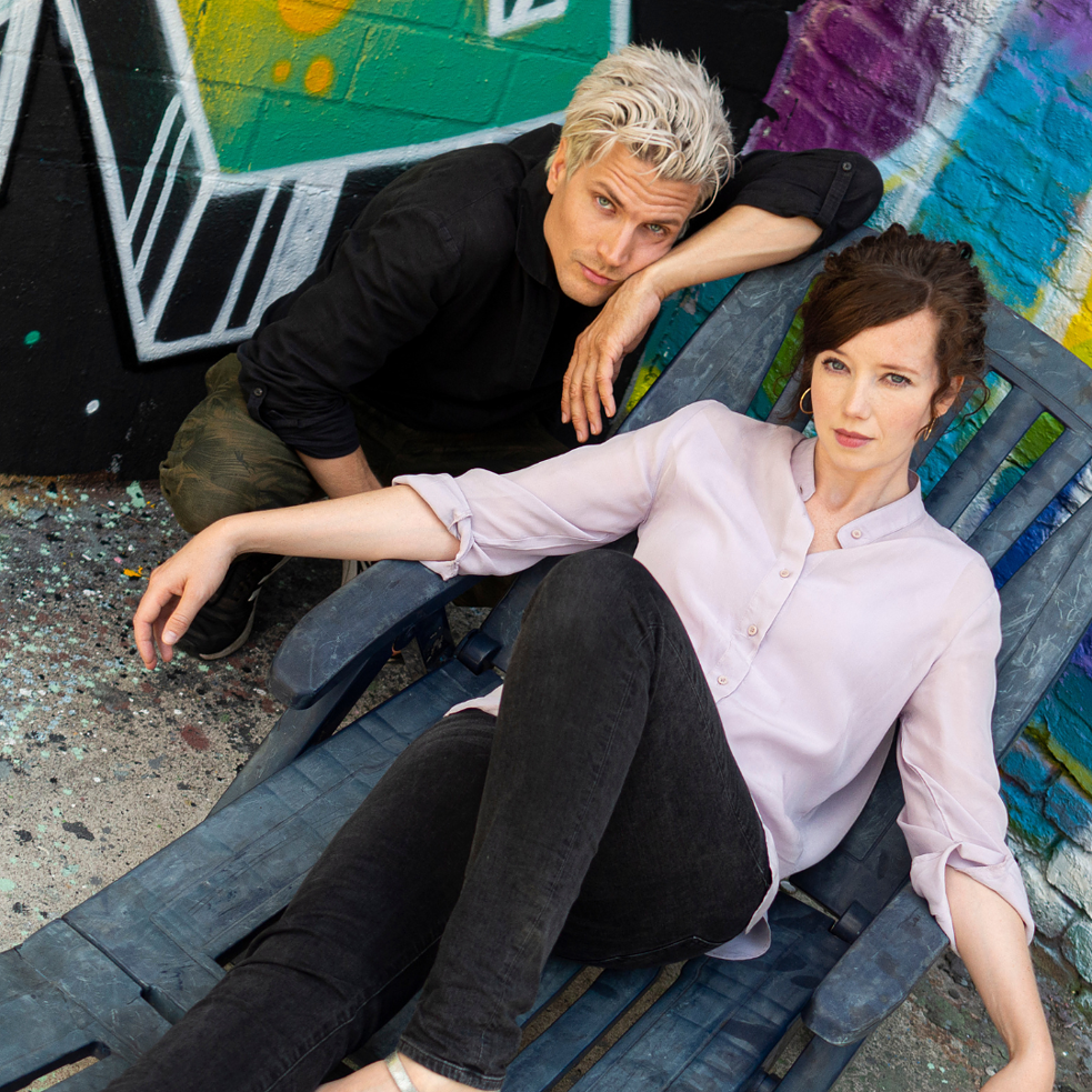 Künstlerduo kennedy+swan vor einer bunten Graffiti-Wand