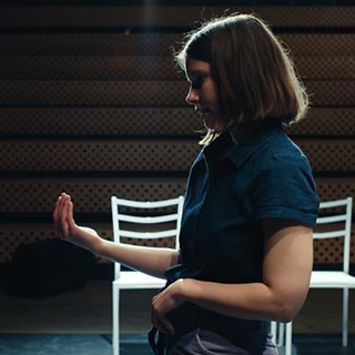 Eine Frau steht im Rampenlicht einer Kamera.