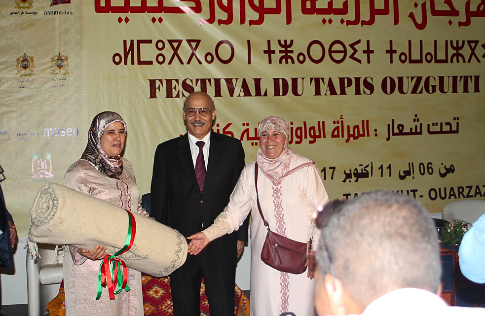 Minister Jamila Al-Musalli receives a gift of a carpet from Safiya Minoutras during the opening of the Oazkitian carpet festival in 2017.