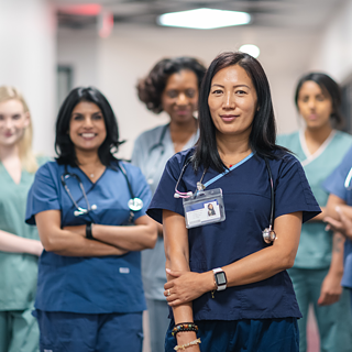 Ein Team von Krankenschwestern und Ärzten steht gemeinsam im Korridor des Krankenhauses. Die Gruppe schaut selbstbewusst in die Kamera, sie lachen. Bildauswahl der Region SAN zur Kultur- und Spracharbeit.