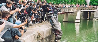A statue is pushed into the river