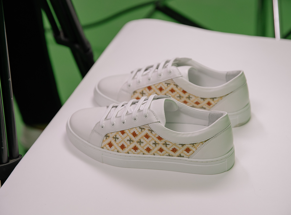 Die jordanische Modedesignerin Farah Ajlouni entwirft Schuhe. Sie lässt von Frauen in Camps mit dem traditionellen Kreuzstich moderne Muster sticken. 