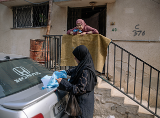 Dalal (vorne) begutachtet die Arbeit einer Stickerin.