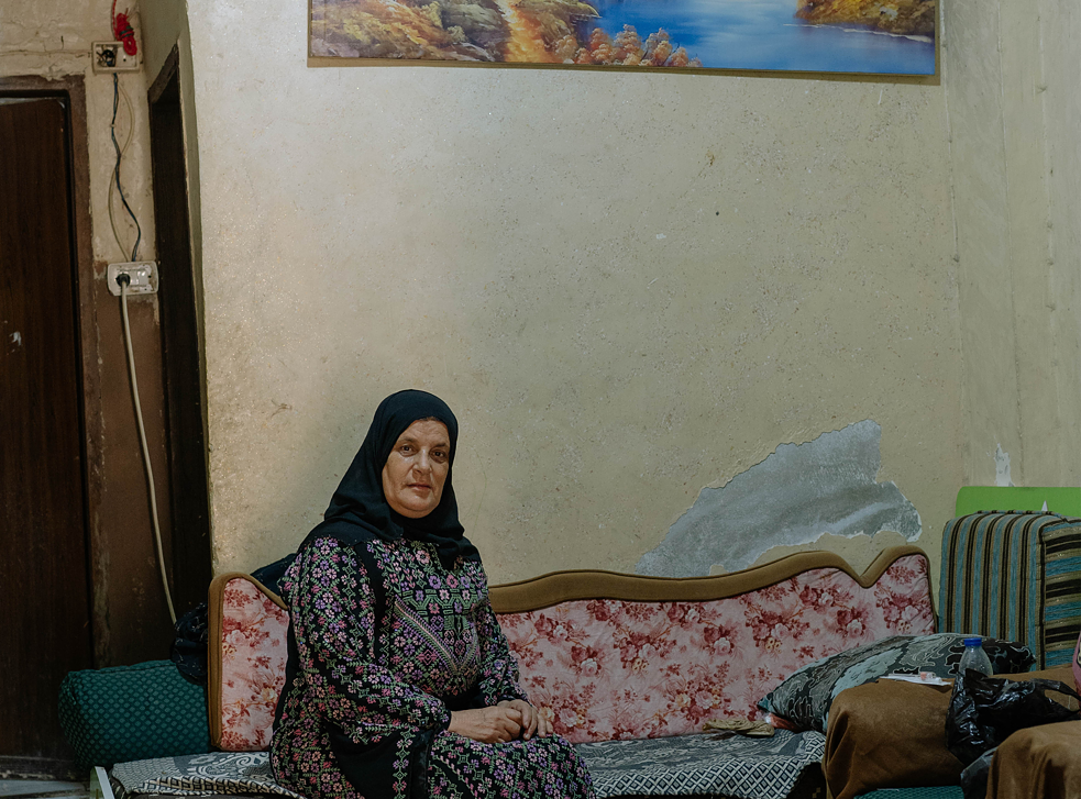 Dalal Abu Shashyh im selbstbestickten Thobe in ihrem Wohn- und Schlafzimmer. 