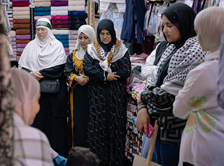 Dalal (Mitte) versammelt sich mit anderen Frauen in einem   Laden nahe der al-Husseini Moschee zum Freitagsgebet. 