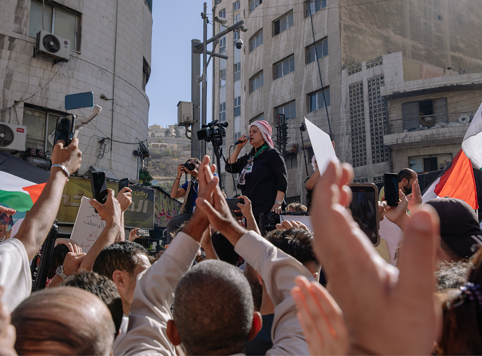 Eine Rednerin ruft ins Mikrofon: „Stoppt die Aggression! Öffnet die Grenzen! Steigt aus dem Friedensvertrag aus!“