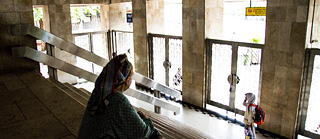 Eine Frau in Saudi-Arabien steht an einem Fenster