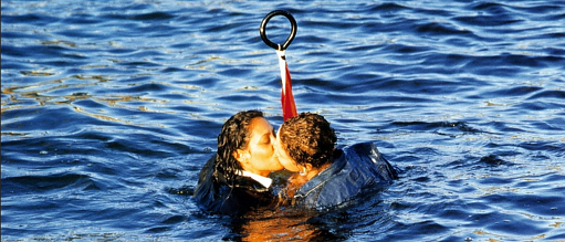 Two women kissing with heads above a sea of water