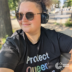 A portrait of a young white woman wearing sunglasses and headphones can be seen. Trees and a path can be seen in the background. In the top right corner is a semi-transparent hashtag sign and above it the word Vorzeichen in white. In the bottom right corner is the logo of the Goethe-Institut.  