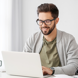 Ein Online Student lernt konzentriert an einem Tisch mit seinem Laptop. Er nutzt digitales Lernen und E‑Learning, um Wissen zu erweitern.