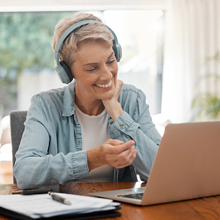 Woman sitting at desk with books and computer