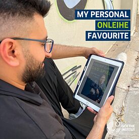 Ein junger Mann liest ein EBook am Tablet