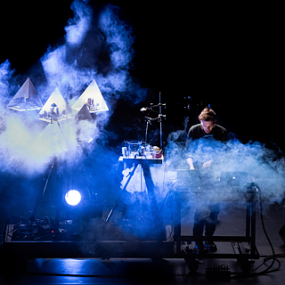 Künstler Moritz Geist auf der Bühne mit blauen Rauchwolken