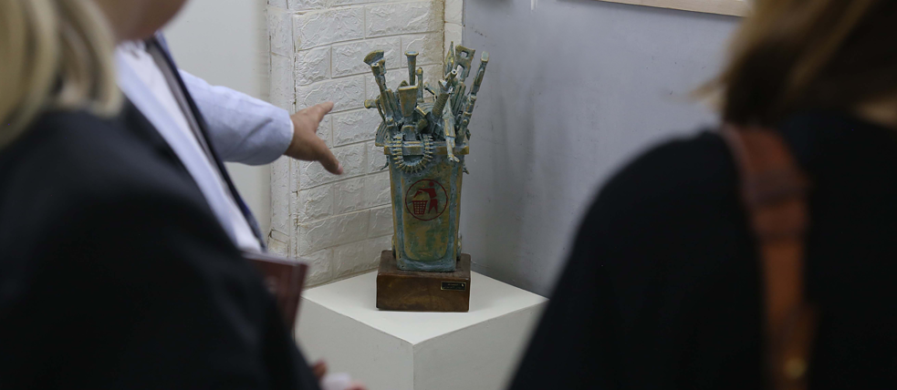 Künstler erklärt zwei Gästen eine Skulptur