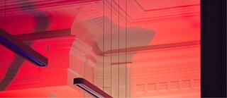 Das Bild zeigt die rotbeleuchtete Decke der Bibliothek.